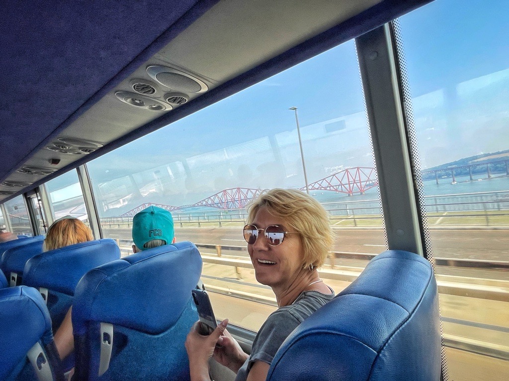 Woman enjoying bus trip across with beautiful views of the Forth Bridge