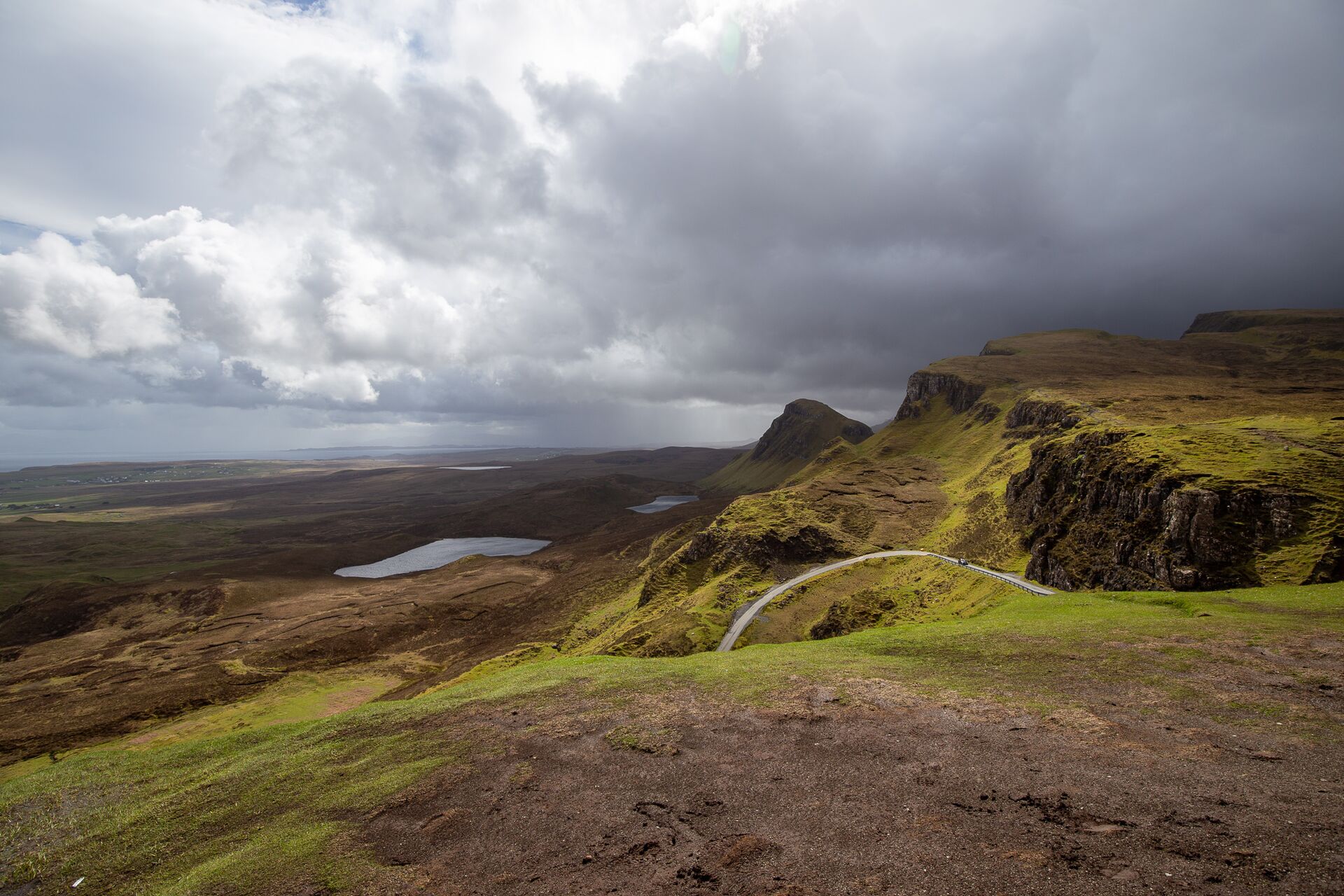 The Quiraing on isle of Skye: green and brown rolling hills with sea lochs in the distance