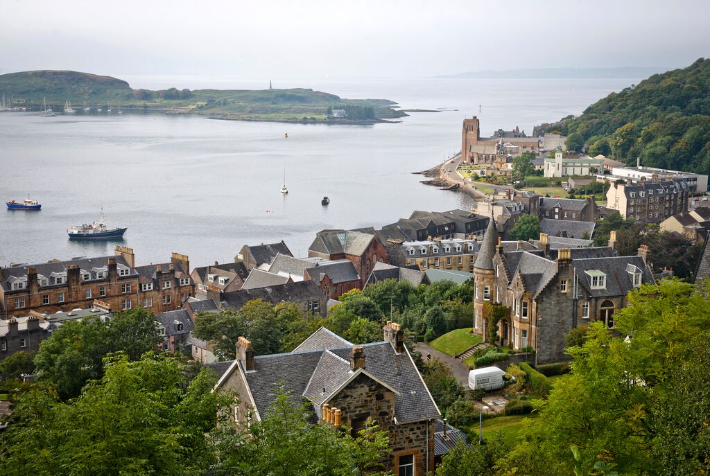 Aerial view of Oban's shores with it's traditional stone buildings, harbour, and trees