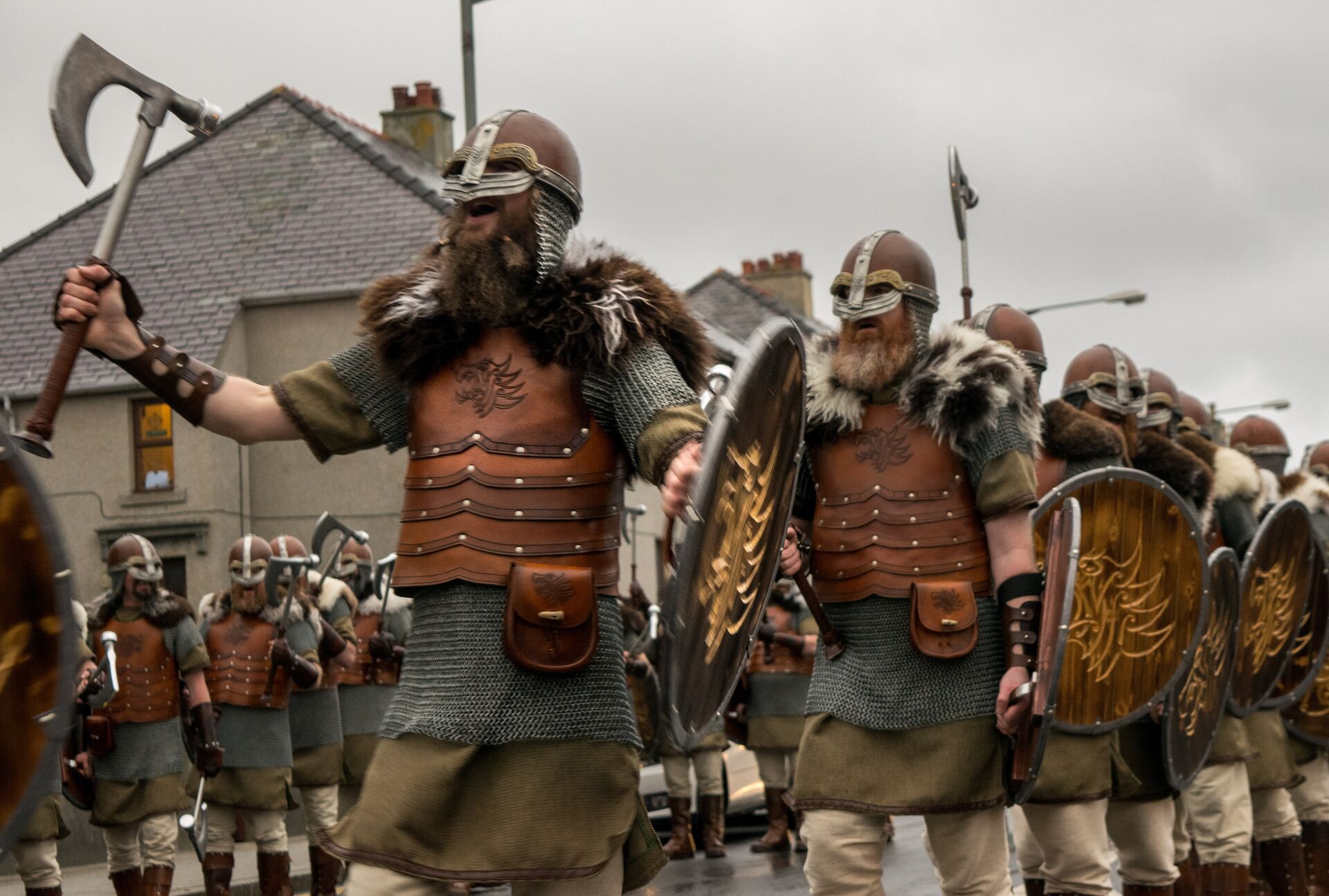 Men dressed in Viking clothing with helmets and axes during the Up Helly Aa parade in daylight